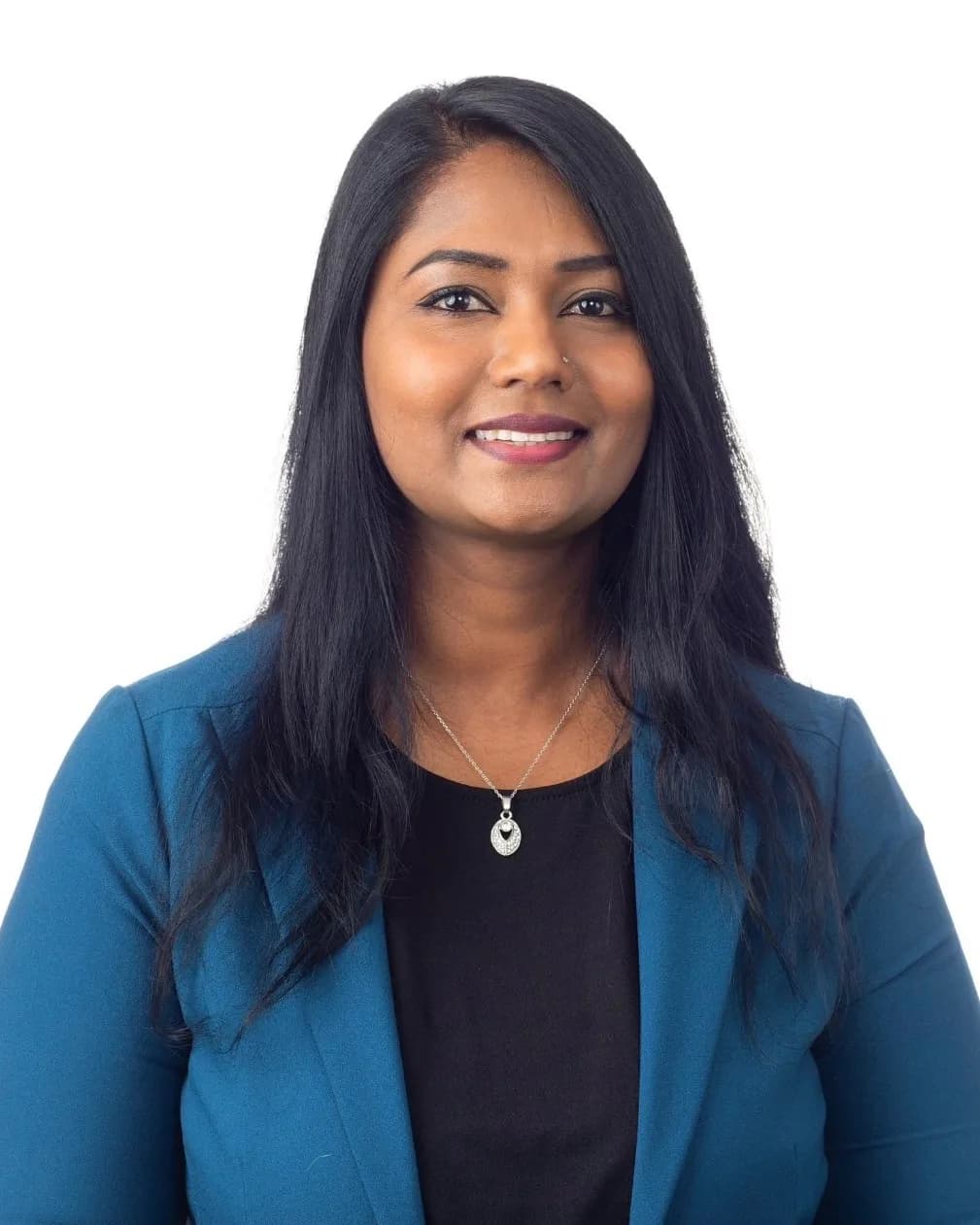 Meena Fisher, wearing a teal blazer, photographed against a plain white studio backdrop.